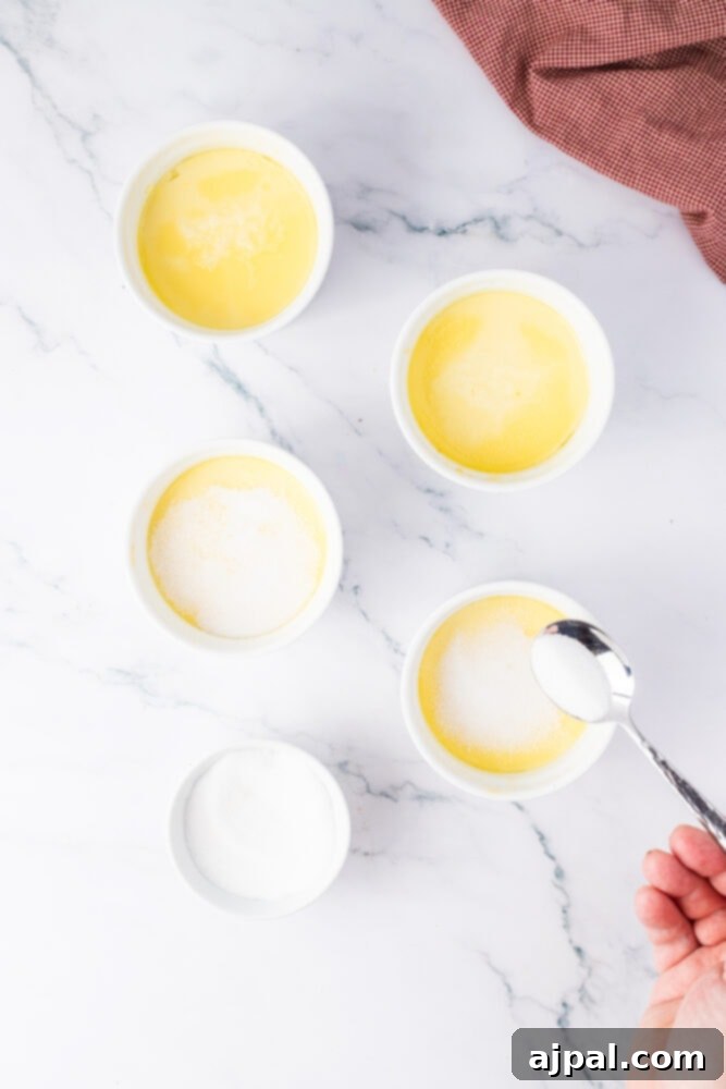 Your Instant Pot's Secret to Perfect Creme Brulee 12 cooked custard in ramekins with sugar being spooned on top