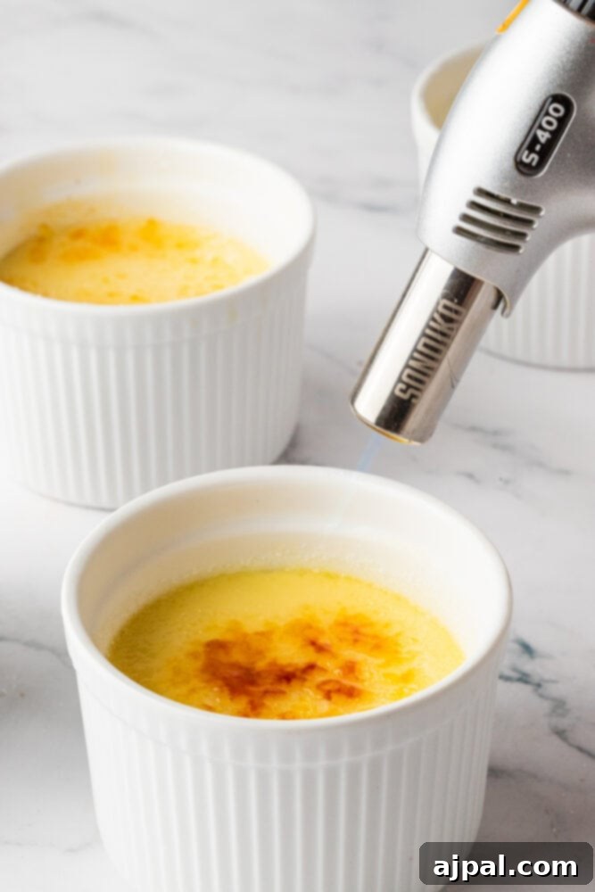 Your Instant Pot's Secret to Perfect Creme Brulee 13 a kitchen torch browning sugar on top of a custard in a ramekin