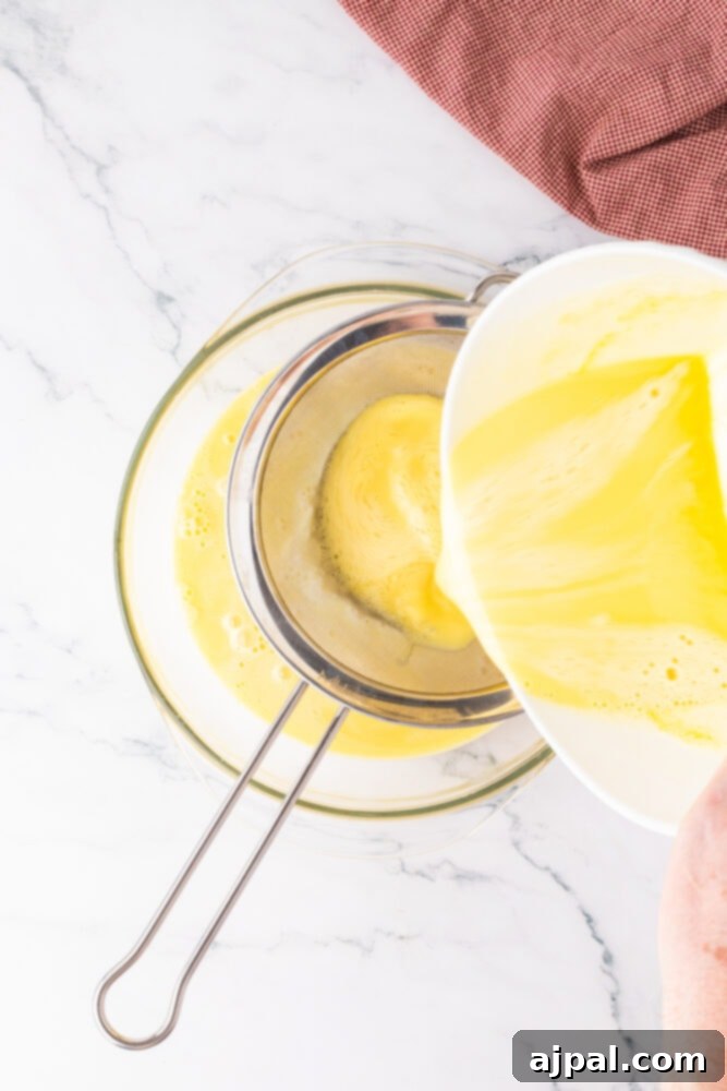 Your Instant Pot's Secret to Perfect Creme Brulee 9 custard being poured through a strainer into a bowl