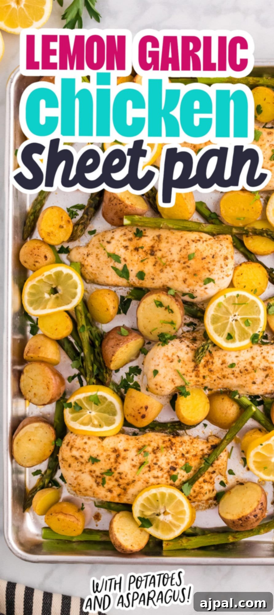 A tall, vertical image of a baked sheet pan lemon garlic chicken dinner with potatoes and asparagus.