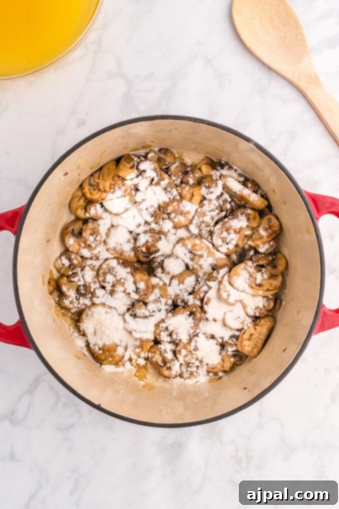 flour over browned mushrooms in a dutch oven