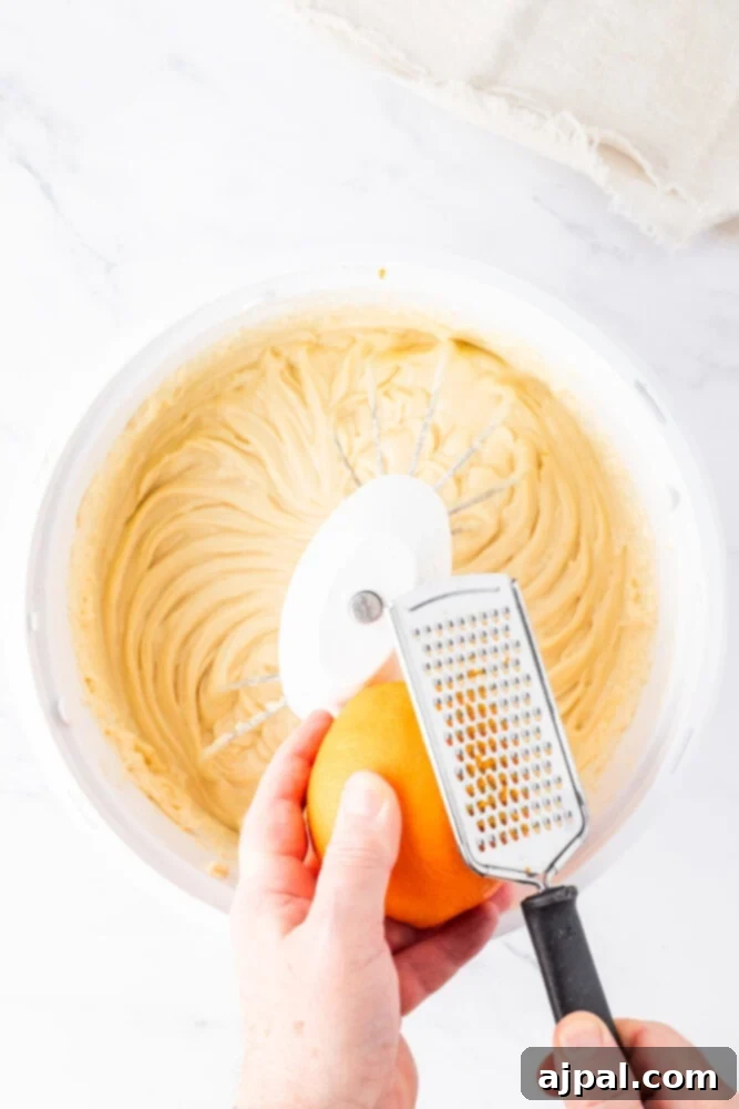 Bright Cranberry Orange Bundt Cake 8 A hand squeezing fresh orange juice into a bowl of wet ingredients, adding citrus flavor.