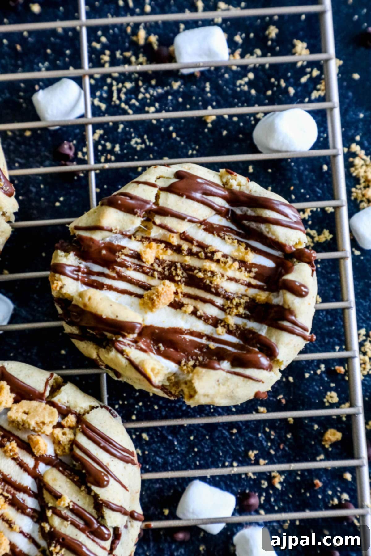 Gluten-Free S'mores Cookies 12 S’mores cookies with gluten free marshmallow and chocolate on a cooling rack.