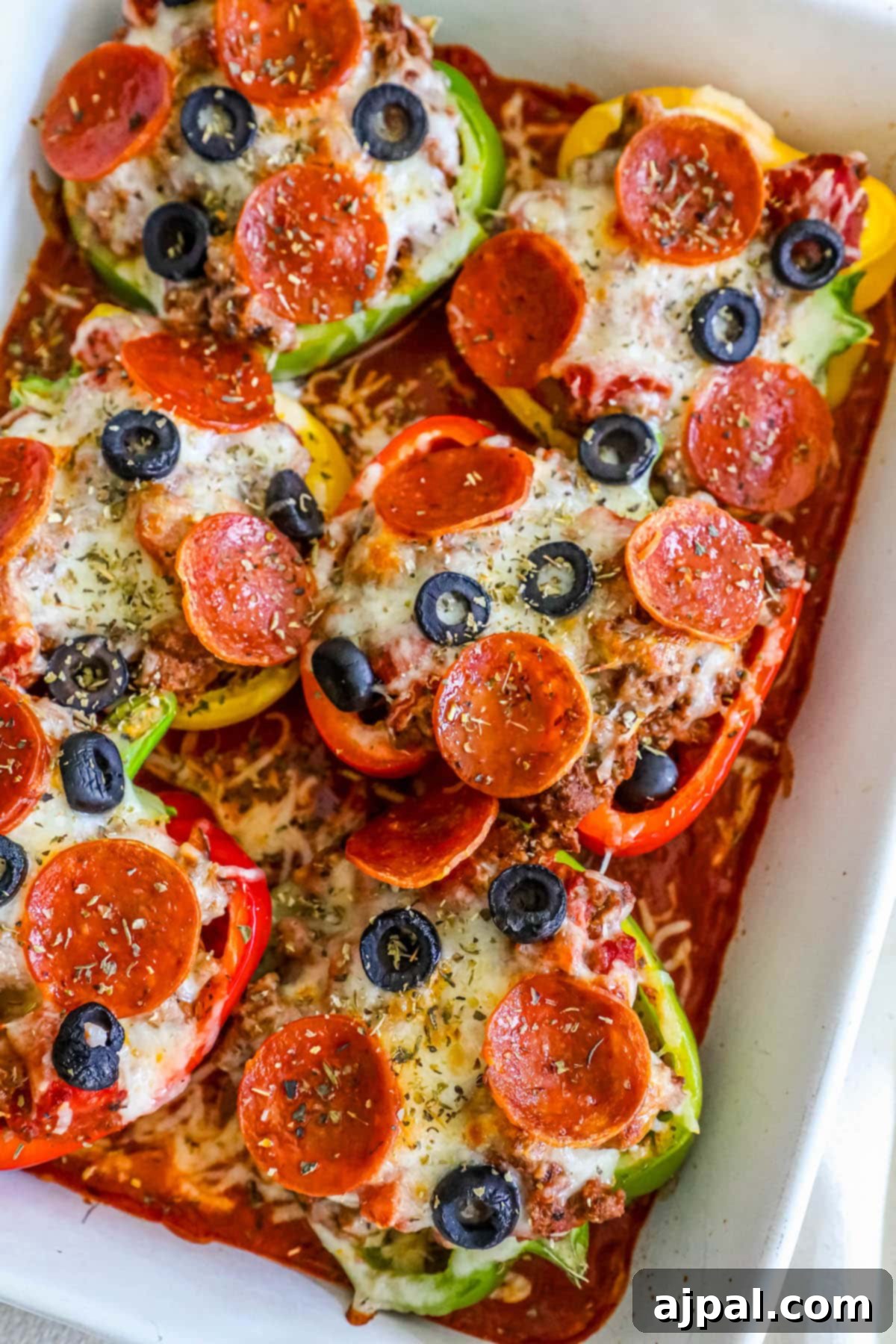 Pepper Pizzas 12 A baking dish filled with several pepperoni-topped pizza stuffed bell peppers, fresh from the oven, showing golden melted cheese.