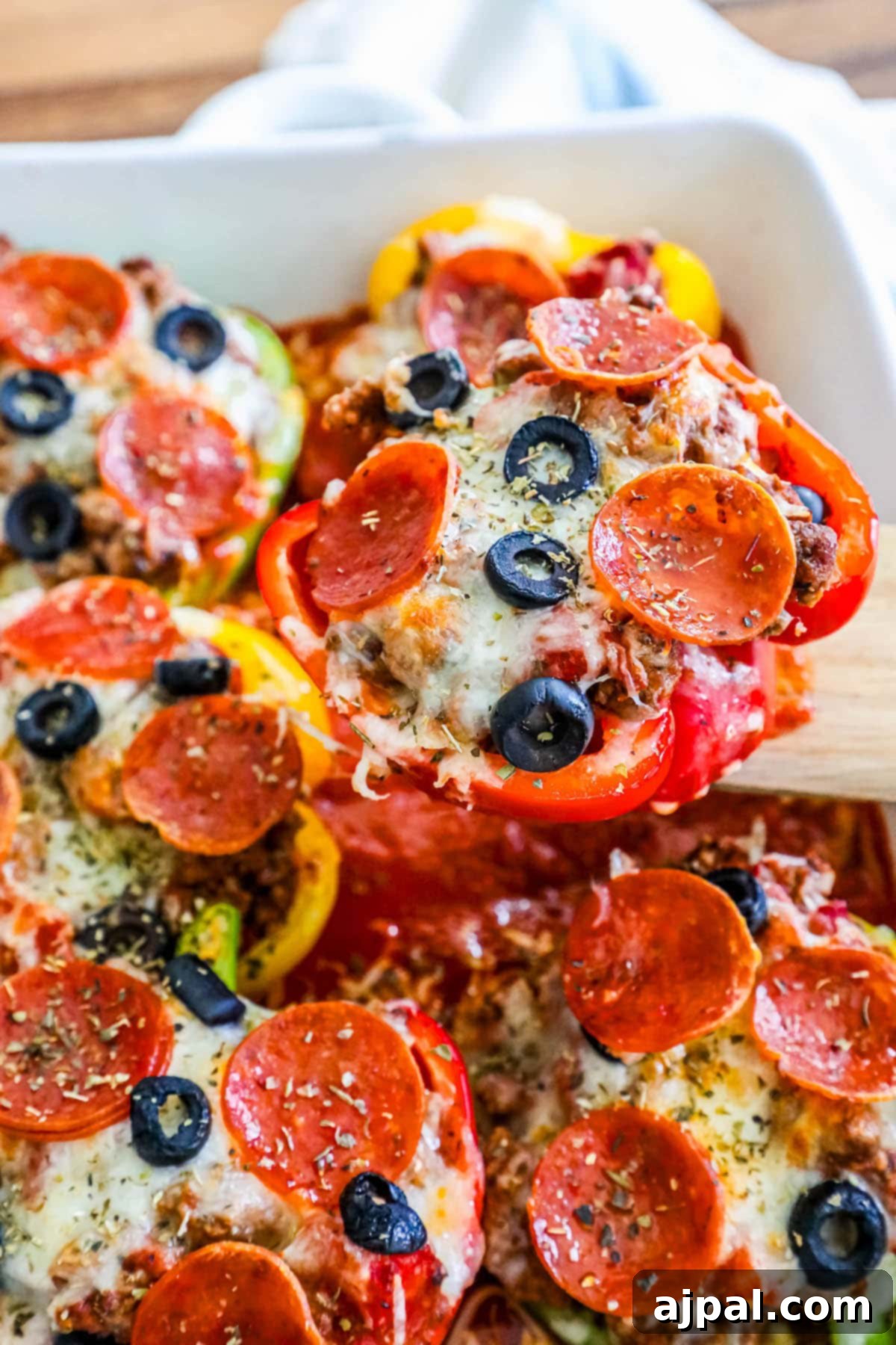 Pepper Pizzas 3 Two bell peppers filled with savory pizza toppings and melted cheese, baked to perfection in a white pan, showcasing a tempting low-carb meal.