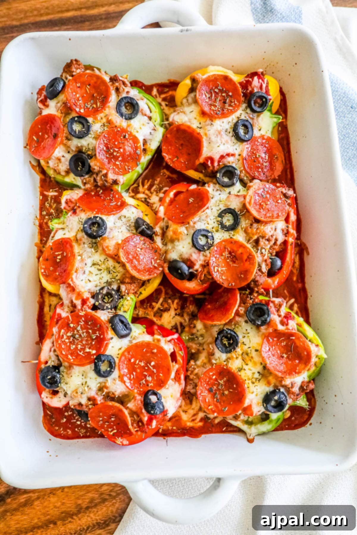 Pepper Pizzas 4 Golden-brown pepperoni and melted cheese atop vibrant bell peppers, baked in a white baking dish for a delicious keto-friendly pizza experience.