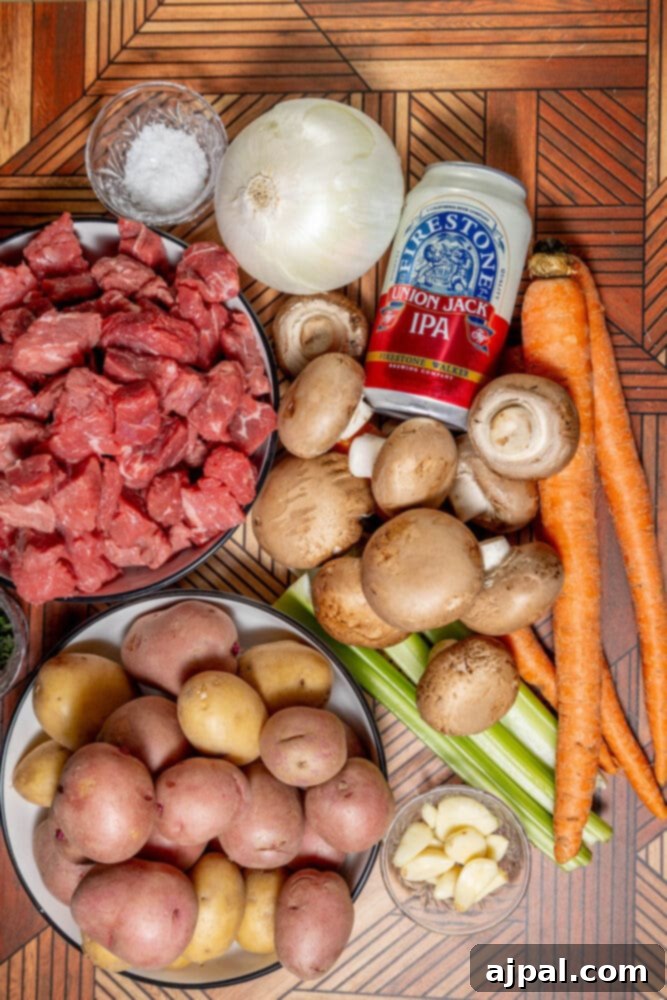 Hearty Beef and Potato Beer Stew 5 Assortment of fresh ingredients for steak and potato beer stew, including cubed meat, mushrooms, carrots, onion, and a can of beer.