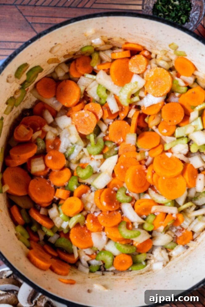 Hearty Beef and Potato Beer Stew 8 Diced carrots, celery, and onion sautéing in a pot with garlic ready to be stirred in.