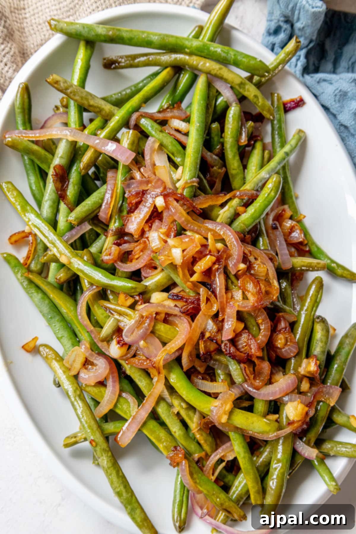 Sautéed green beans with red onion, served on a white plate.