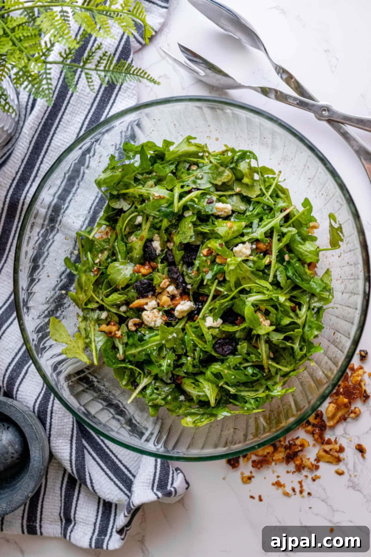 A beautifully presented salad featuring fresh arugula, crunchy walnuts, and savory white cheese.