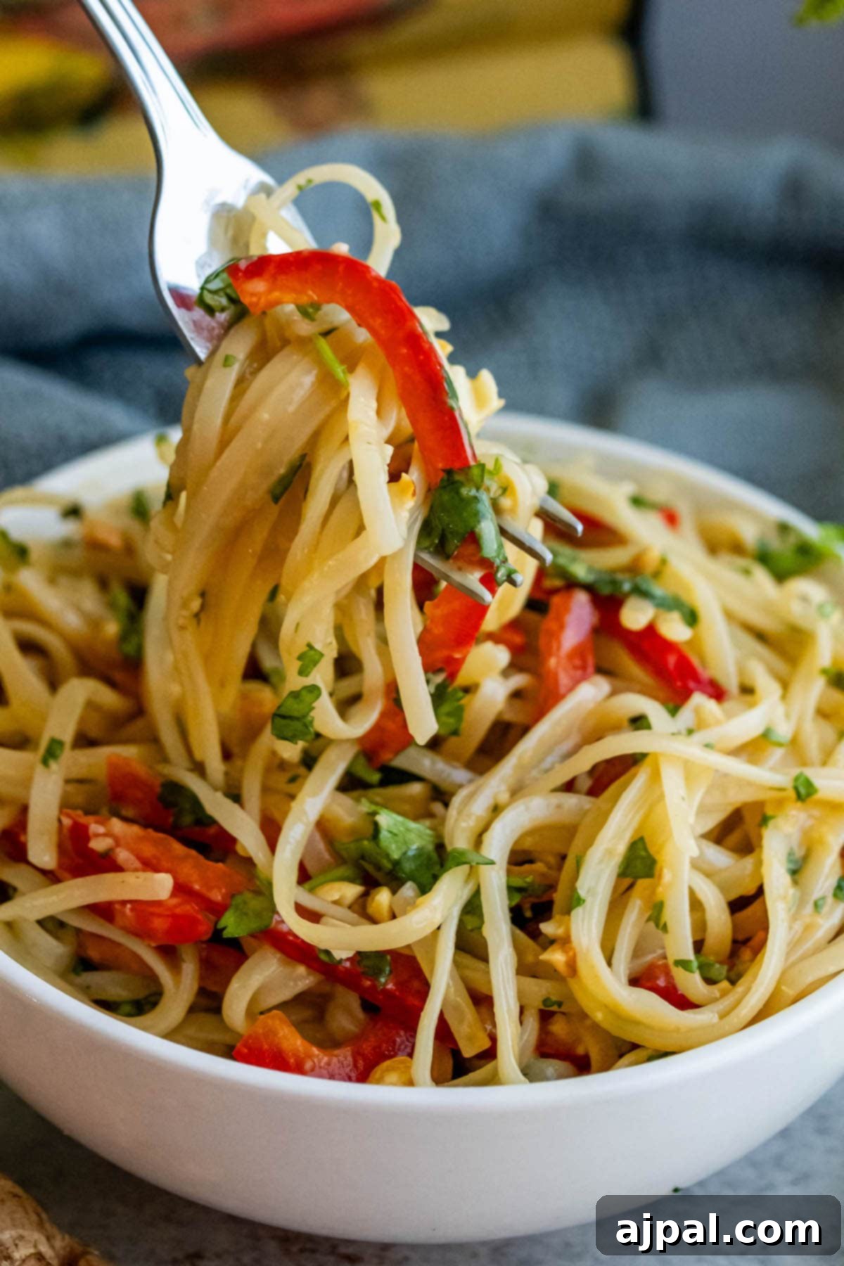 A vibrant bowl of pasta mixed with colorful peppers and aromatic herbs, showcasing the deliciousness of Miso Noodle Salad.
