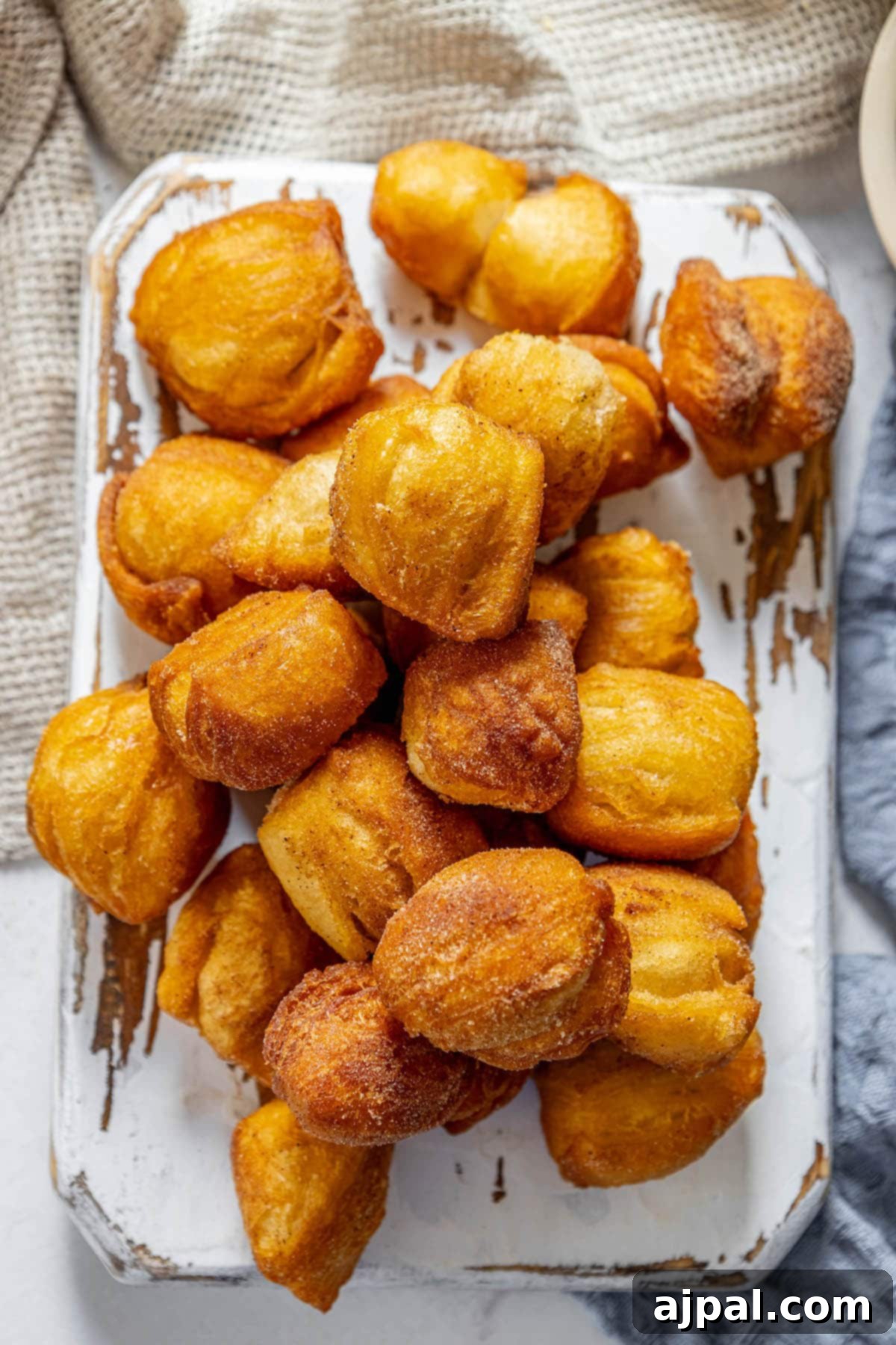 Golden Cinnamon Bites 2 A plate of fried doughnuts on a table, also known as fried cinnamon biscuits.
