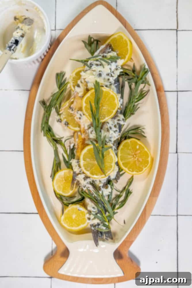 Roasted Branzino with Zesty Lemon-Caper Butter 11 A serving of roasted branzino and vibrant orange slices, lavishly topped with the flavorful Lemon Caper Butter.