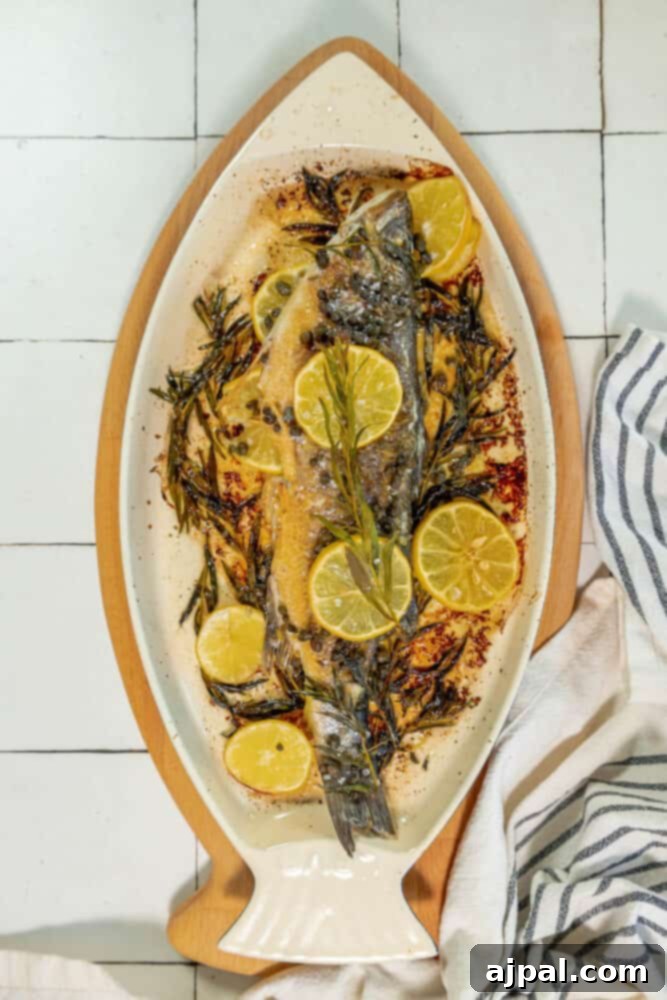 Roasted Branzino with Zesty Lemon-Caper Butter 12 An artfully arranged plate of lemon-infused baked fish, garnished with fresh herbs for a perfect finish.