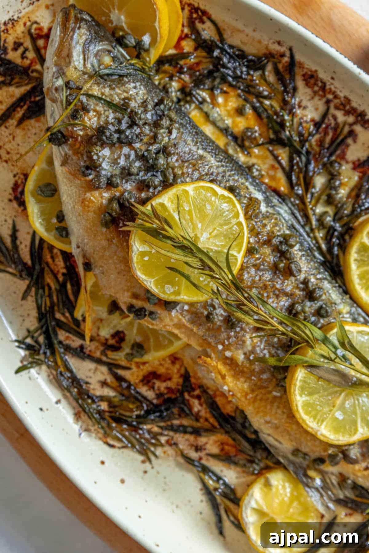 Roasted Branzino with Zesty Lemon-Caper Butter 3 A succulent roasted Branzino fish, elegantly presented with bright lemon slices, awaiting its first taste.
