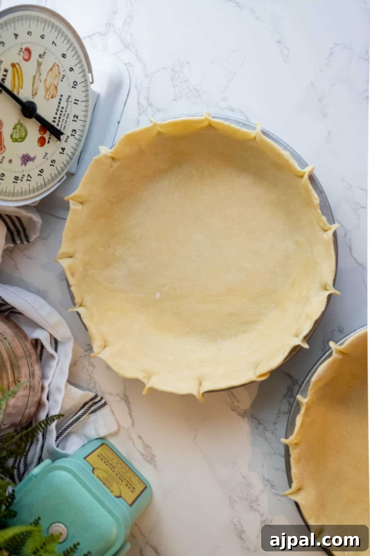 Foolproof Pie Crust 4 Two pie crusts next to a measuring scale on a table.