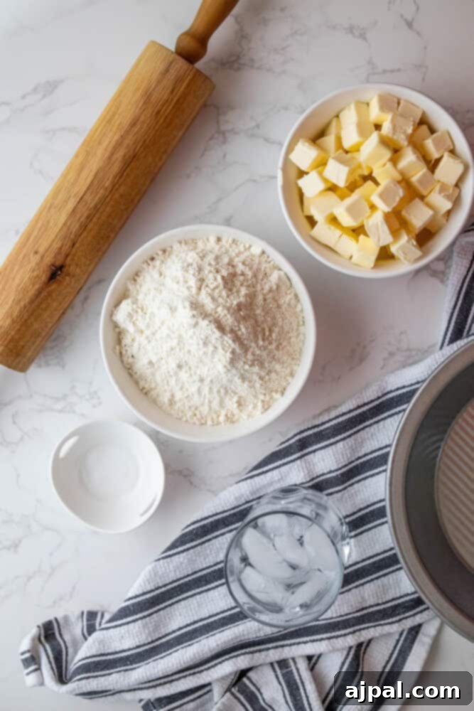 A bowl of flour and a rolling pin on a marble countertop make for an easy pie crust.