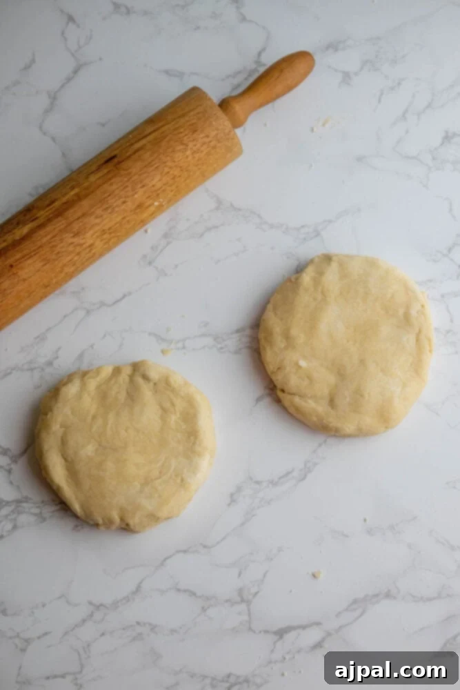 Easy pie crust and rolling pin on a marble table.