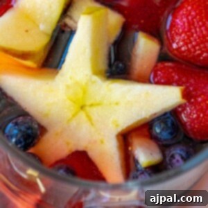 Stars and Stripes Celebration Punch 13 picture of patriotic fruit punch in a pitcher with strawberries, blueberries, and star shaped apple slices