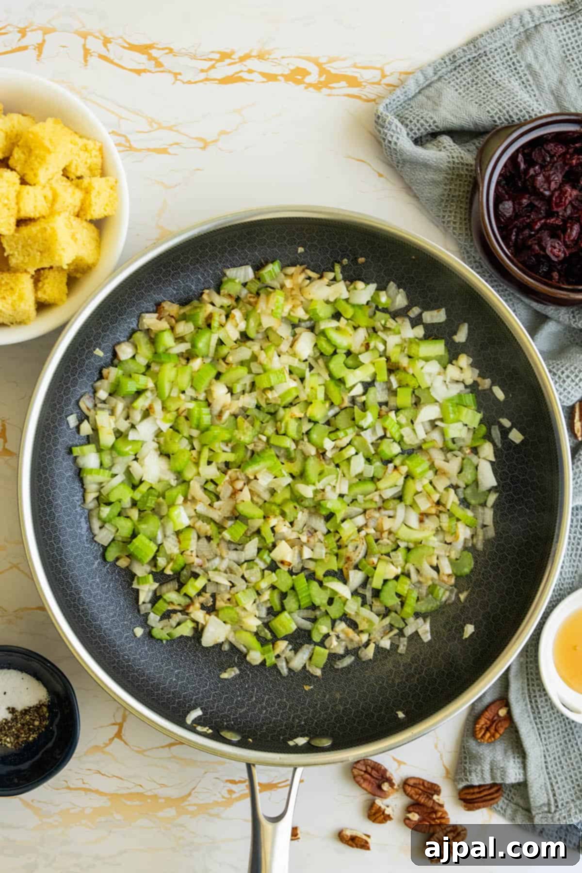 Hearty Sausage Cornbread Dressing 7 A frying pan with sautéed onions, celery, and garlic.
