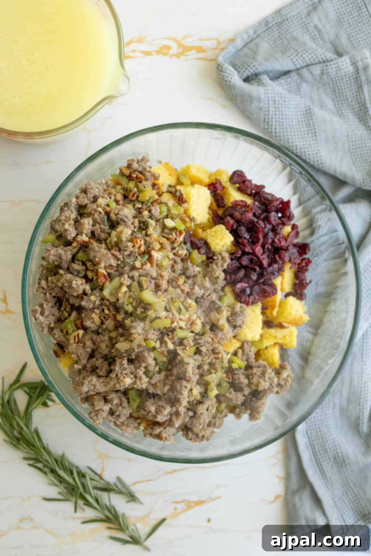 Hearty Sausage Cornbread Dressing 9 Meat and cornbread stuffing ingredients mixed in a large glass bowl.