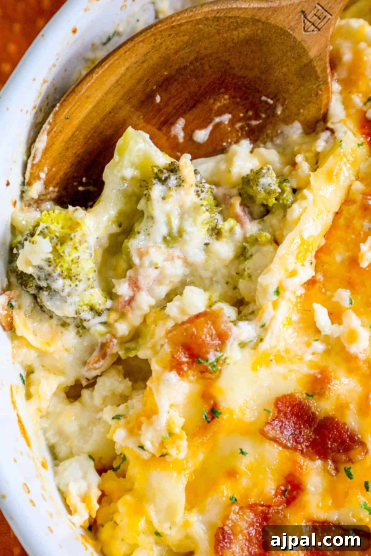 A hearty casserole featuring broccoli, cauliflower, and bacon, perfectly baked and ready to be served from a white dish.