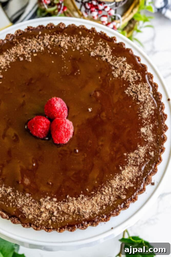 Silky chocolate tart with fresh raspberries as garnish.