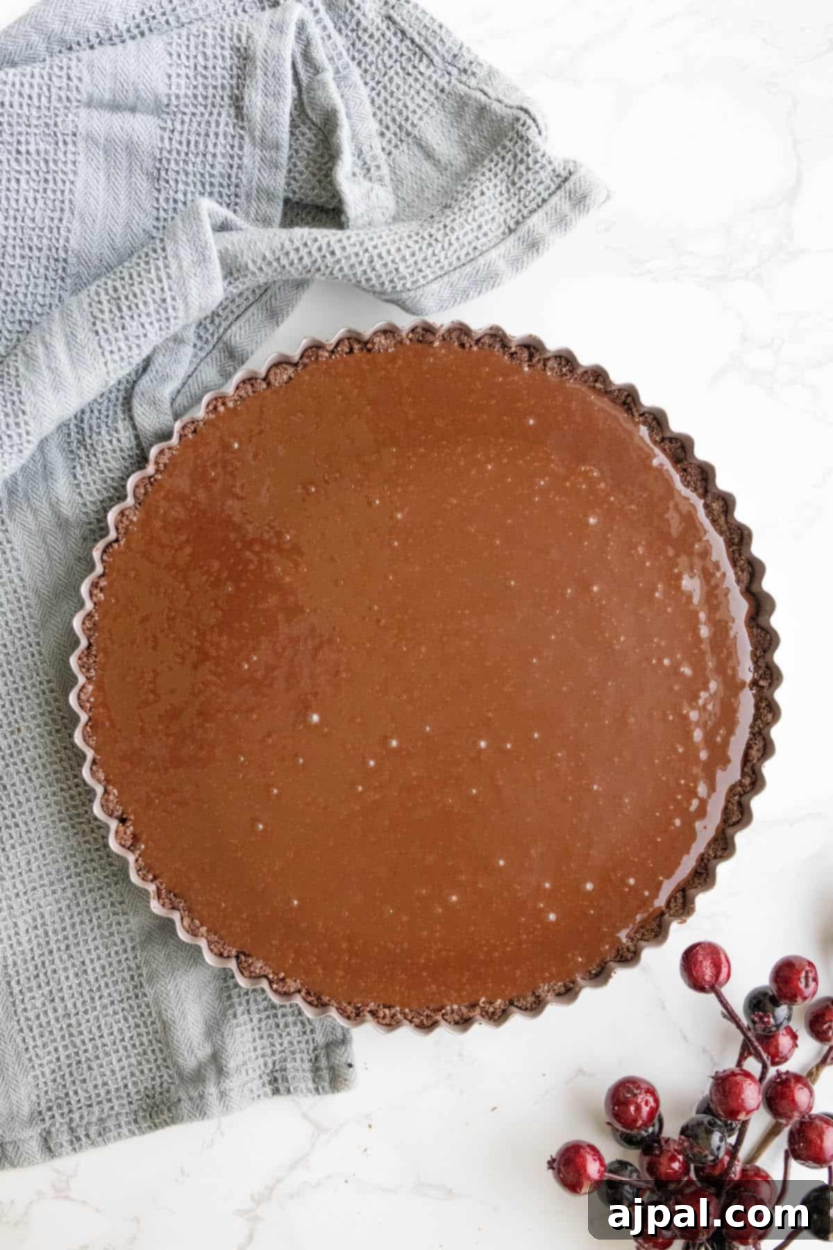 Applying a mirror glaze to a silky chocolate tart.
