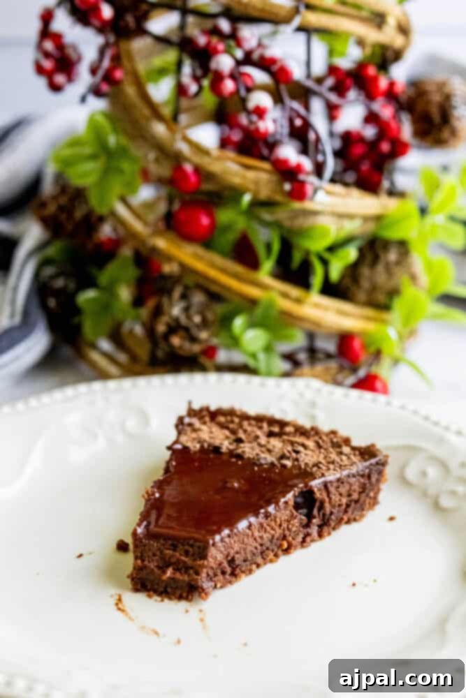 Close-up of a richly glazed silky chocolate tart, showcasing its smooth texture.