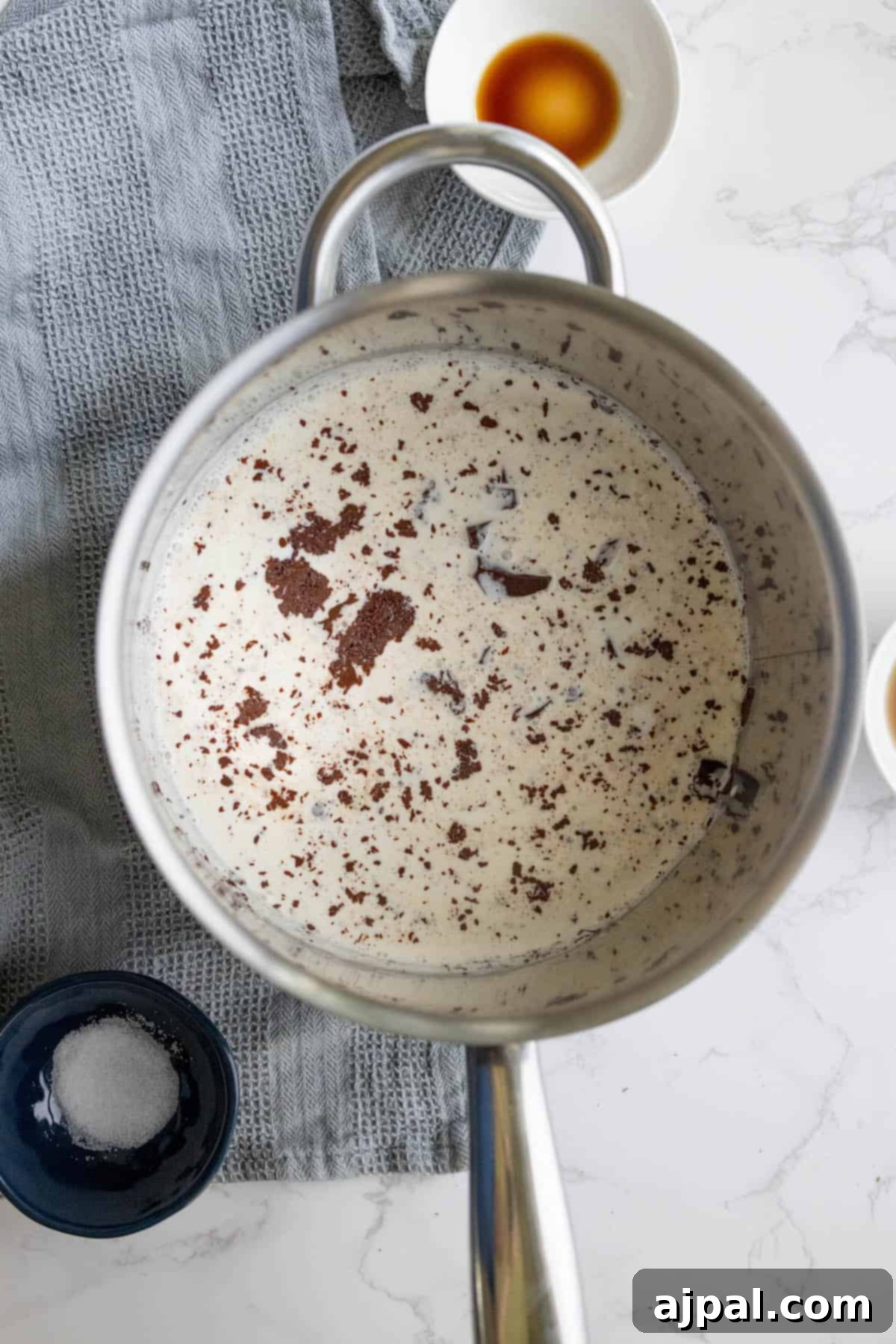 Preparing the chocolate ganache filling for a silky chocolate tart in a pan.