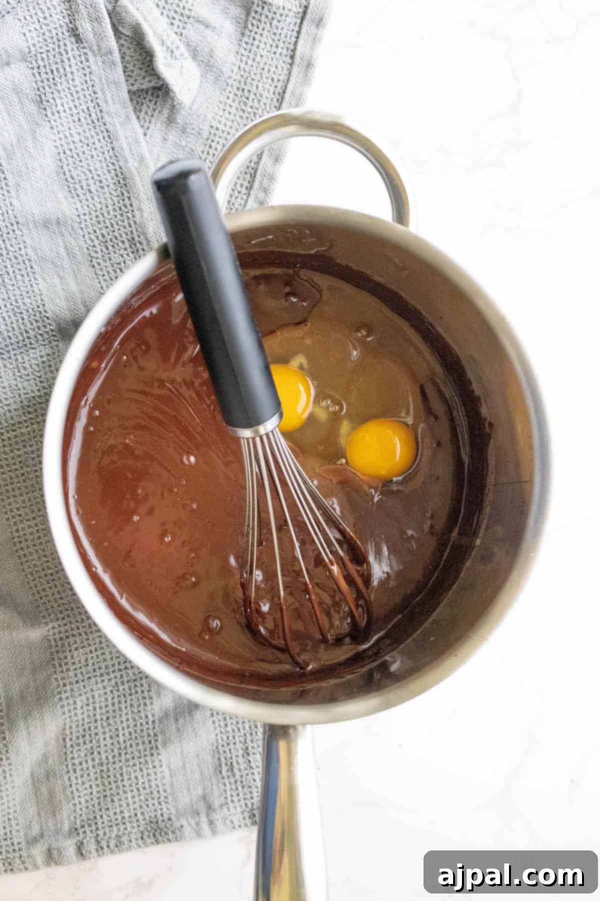 Whisking eggs into the silky chocolate mixture for the tart filling.