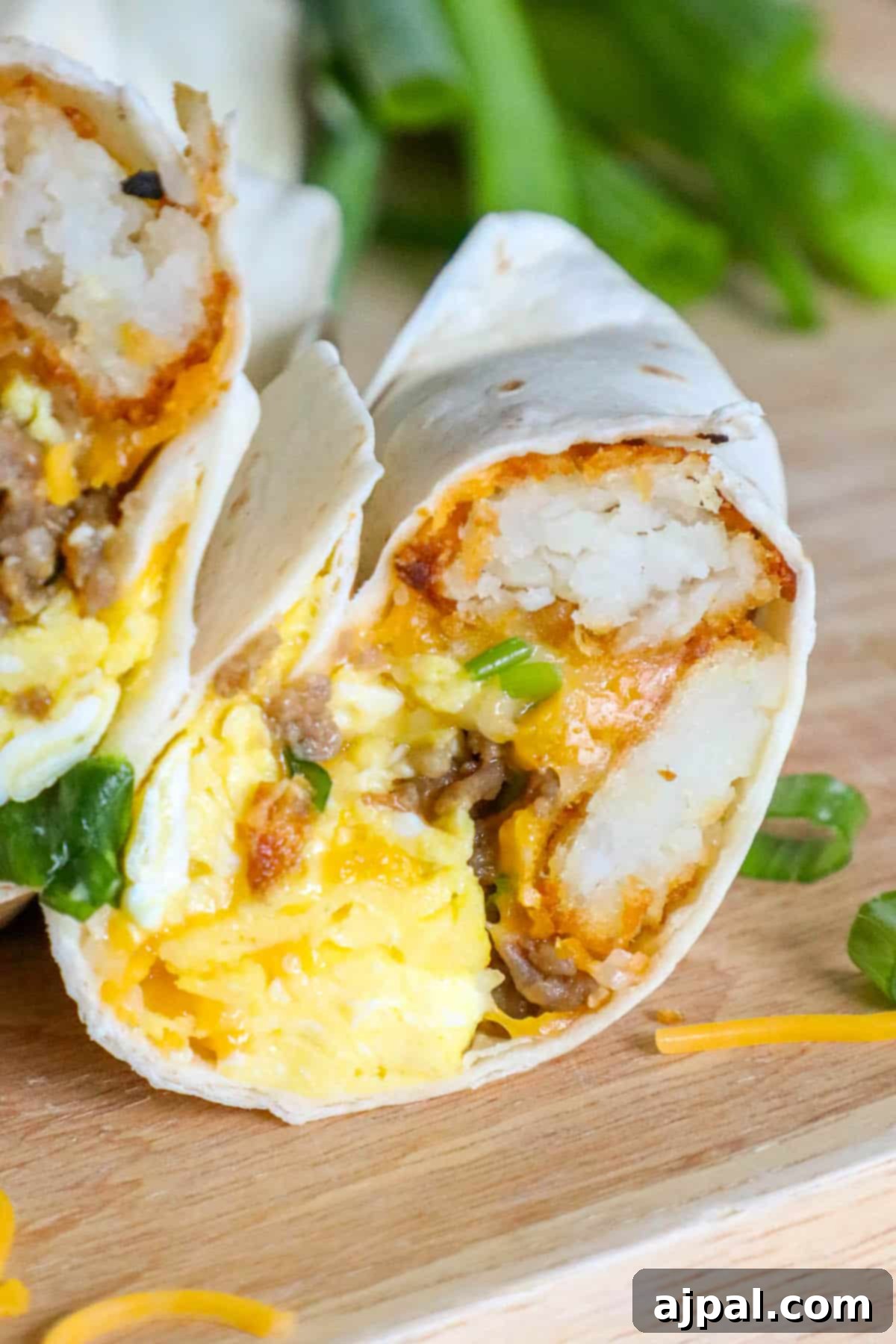 Grab-and-Go Breakfast Burritos 2 A hearty freezer breakfast burrito with eggs and melted cheese, resting on a rustic cutting board, ready to be enjoyed.