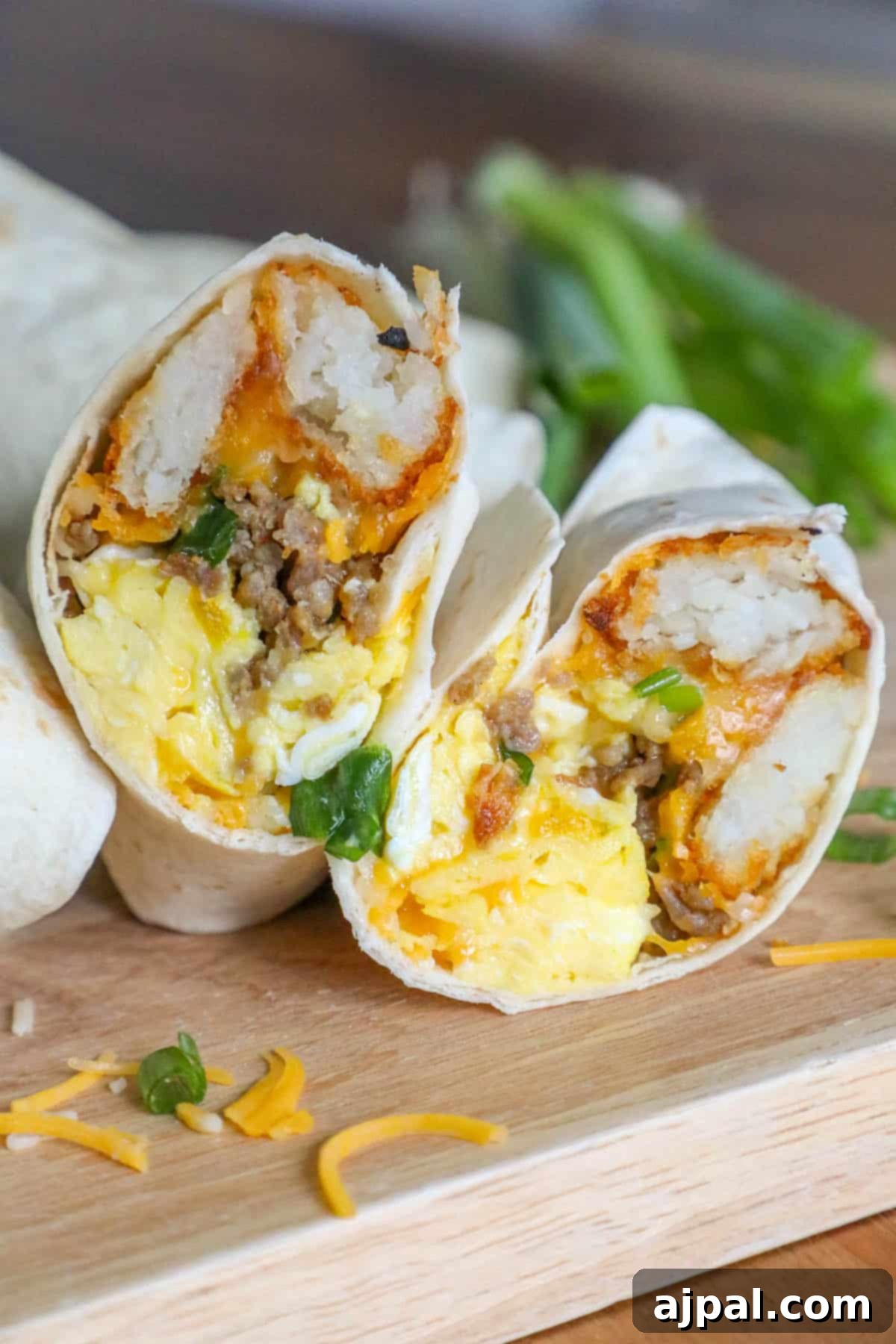 Grab-and-Go Breakfast Burritos 3 A pair of wholesome freezer breakfast burritos, showcasing the golden-brown tortillas and savory fillings, neatly arranged on a wooden cutting board.