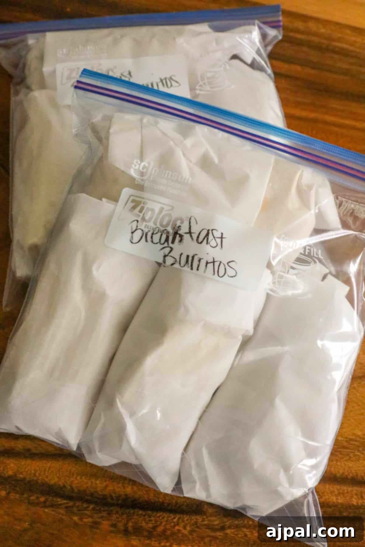Grab-and-Go Breakfast Burritos 7 A selection of raw ingredients, including meat and vegetables, neatly arranged on a wooden surface, ready for meal preparation into delicious freezer burritos.