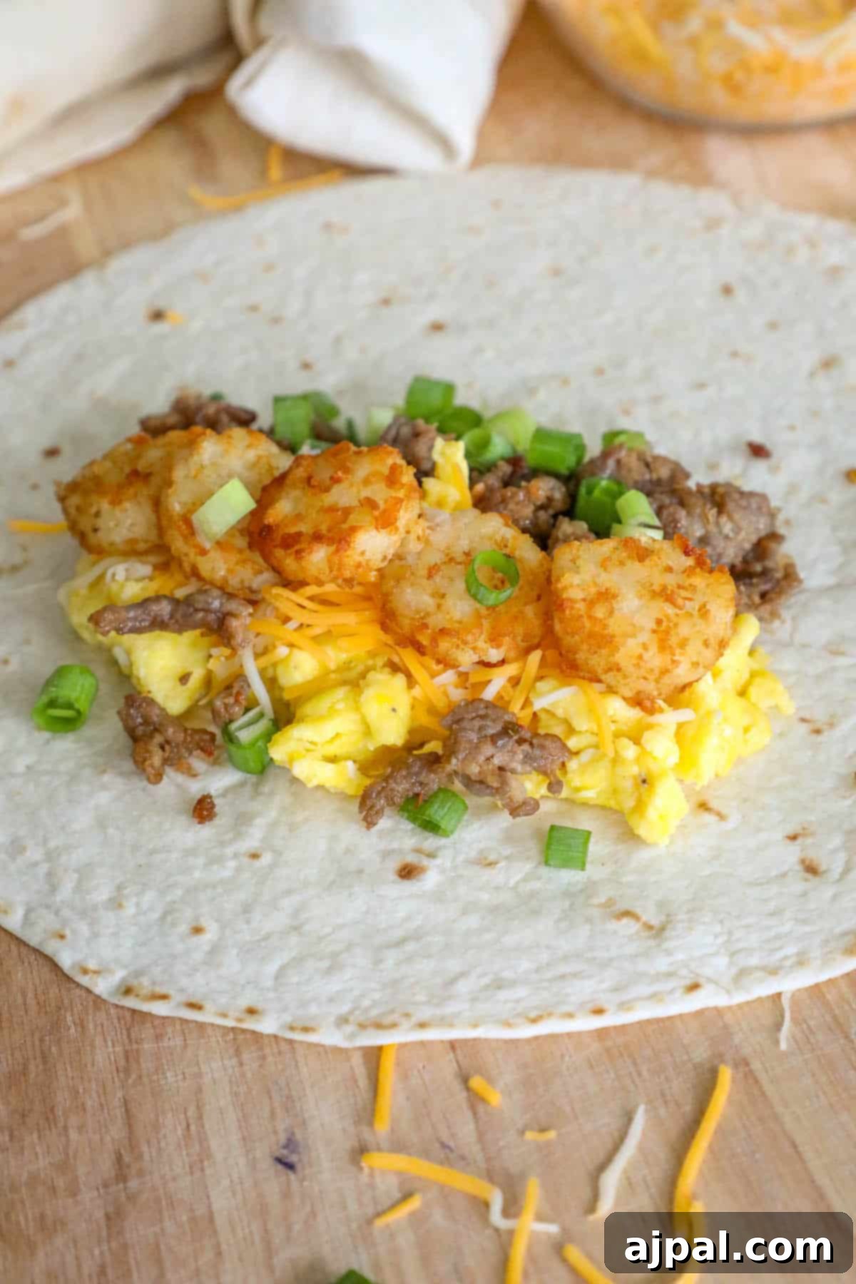 Grab-and-Go Breakfast Burritos 9 A freshly prepared freezer breakfast burrito, showcasing the savory sausage and eggs, alongside a wooden cutting board.
