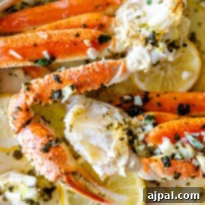 Baked Snow Crab Legs with lemon and herbs on a plate.