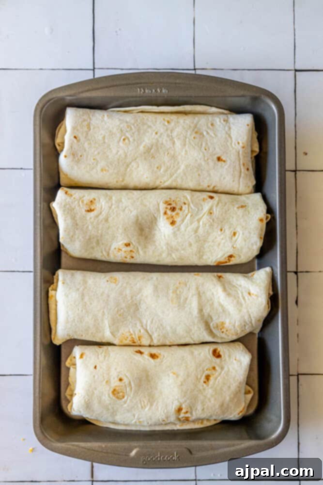 Oven-Baked Chicken Chimichangas 13 Close-up of baked chicken chimichangas in a pan.