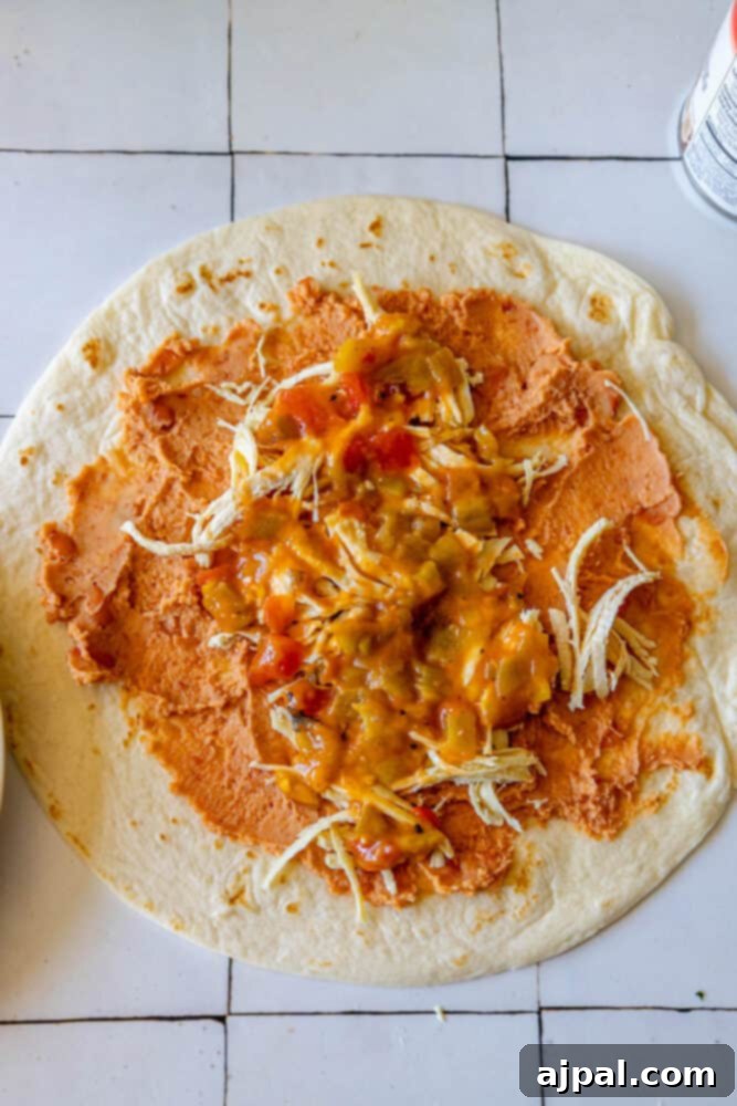 Oven-Baked Chicken Chimichangas 8 Adding shredded chicken to a tortilla.