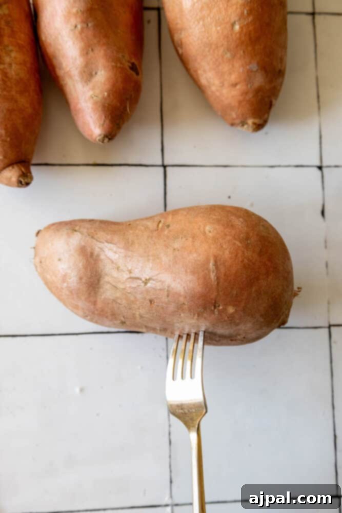 A person holding a fork near salt-baked sweet potatoes.