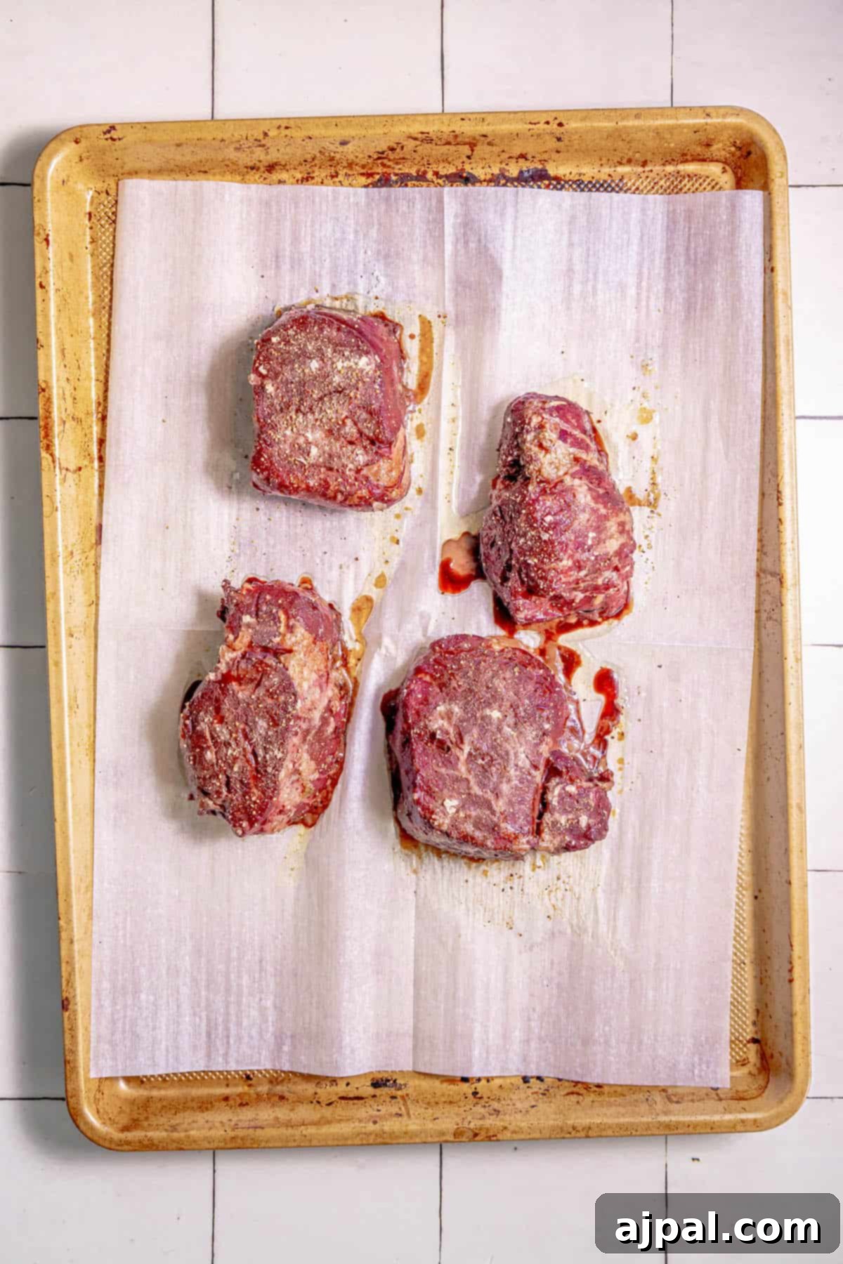 Perfectly Reverse Seared Filet Mignon 8 Four reverse sear filet mignon steaks on a tray on a tiled floor.