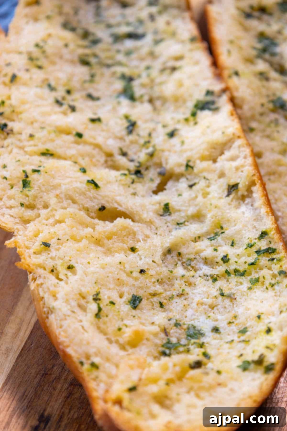 Two slices of garlic bread on a cutting board.