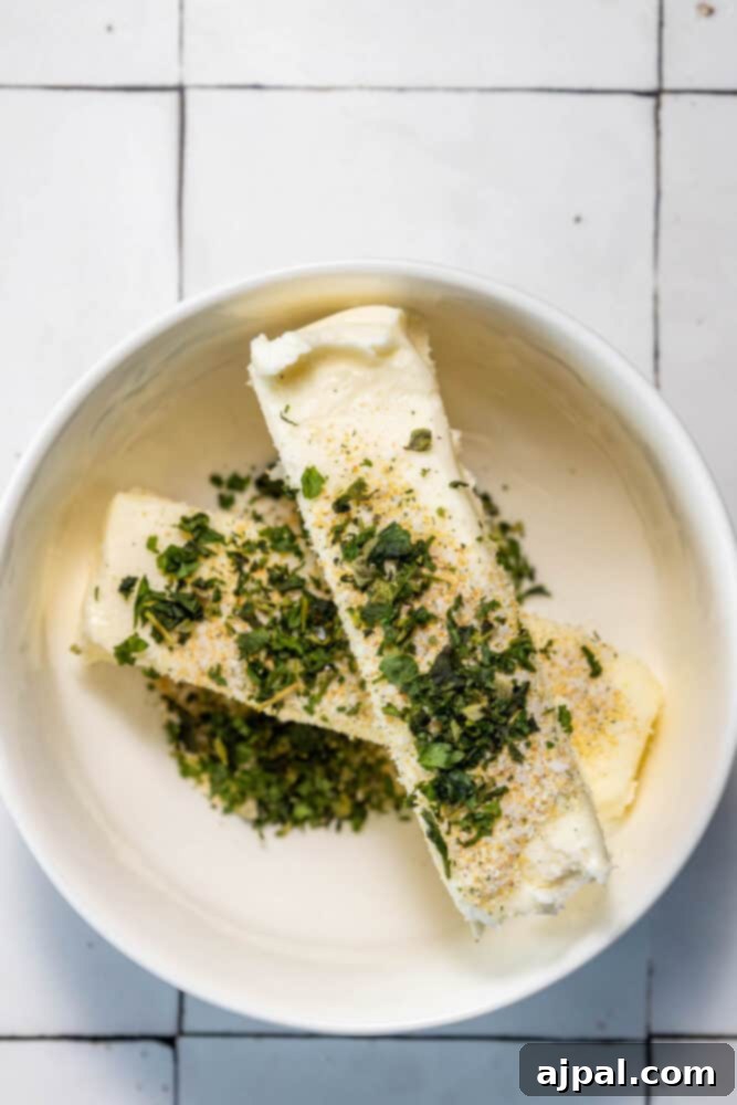 A white bowl with a piece of cheese and herbs on it, showcasing Easy Garlic Bread.
