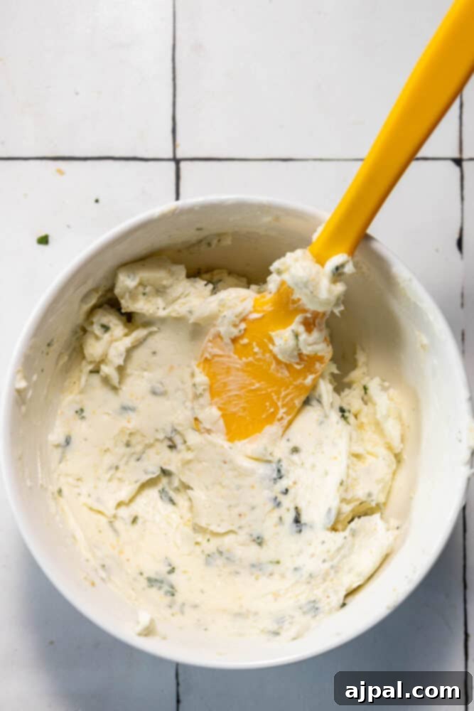 A bowl of whipped cream with a yellow spatula.