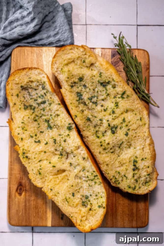 Two slices of bread with rosemary on a cutting board.