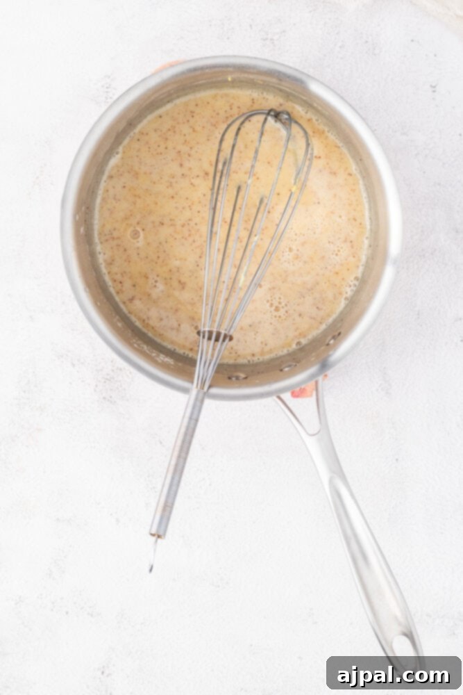 Festive Eggnog Tart 8 A whisk in a frying pan.
