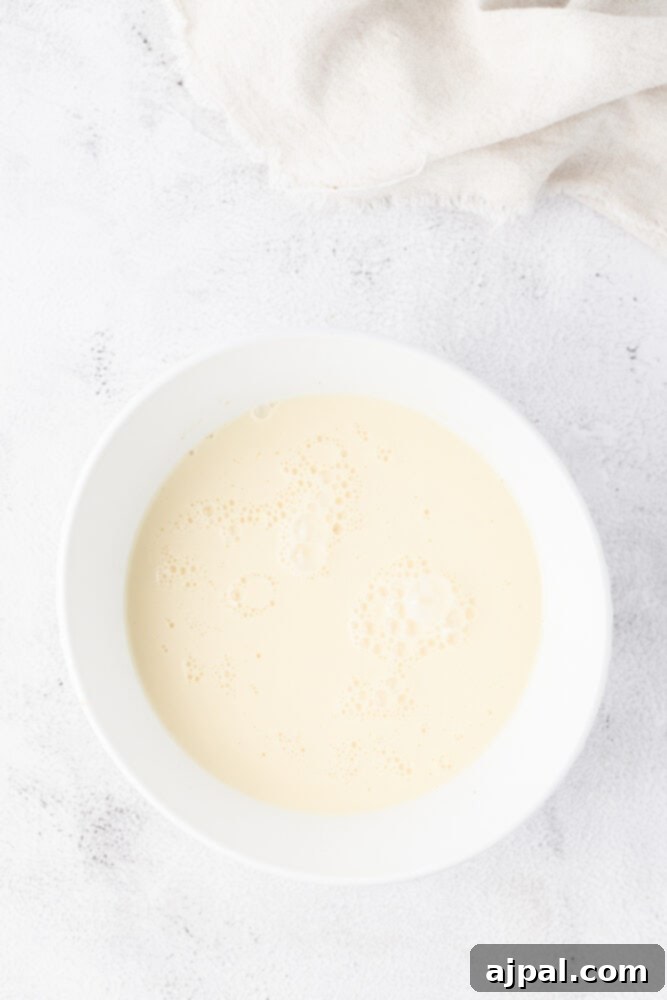 Festive Eggnog Tart 9 A white bowl with a white liquid in it, resembling eggnog.