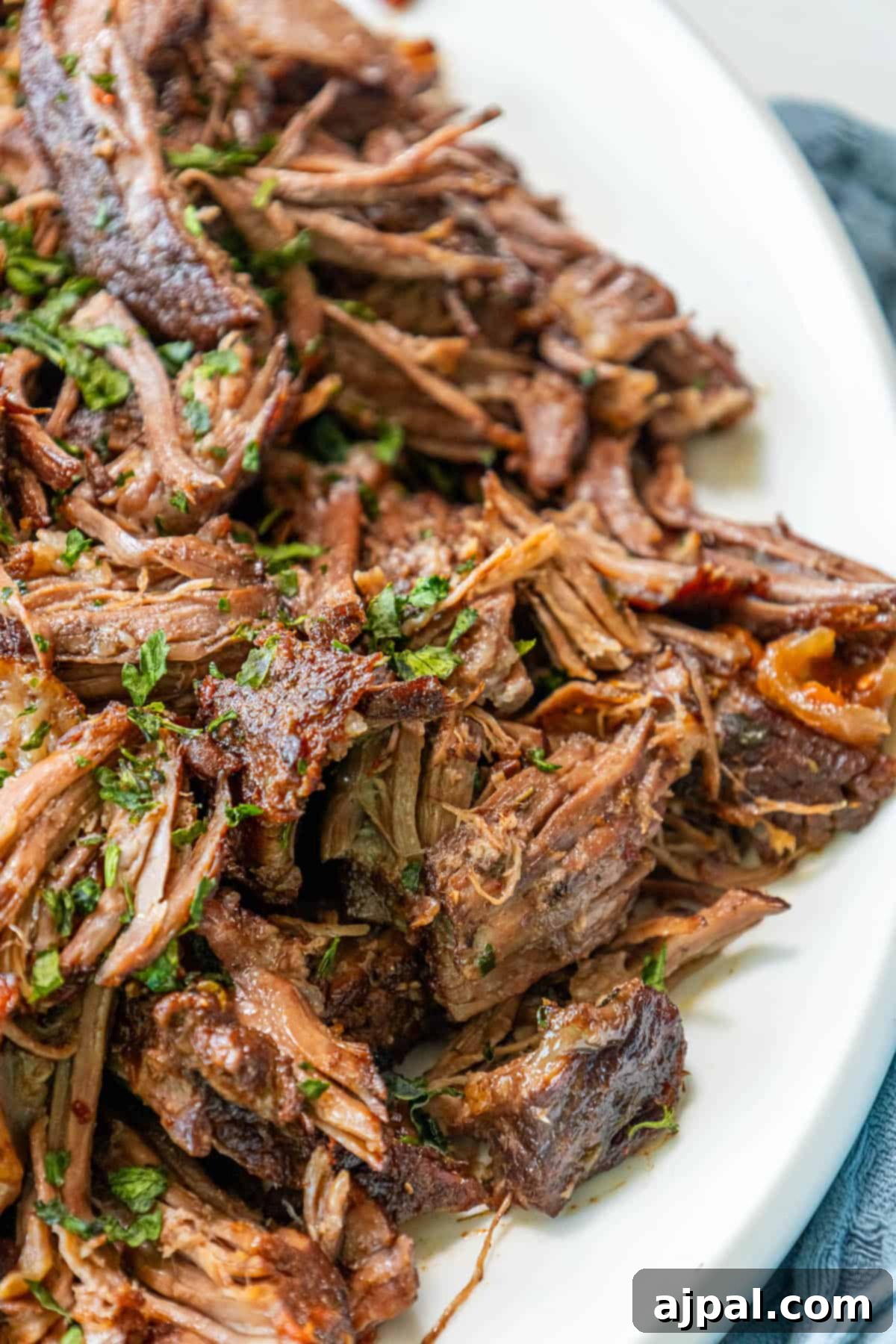 A serving of Perfect Chuck Roast on a white plate, ready to be enjoyed.