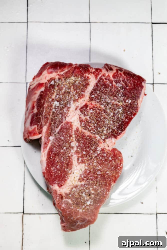 A perfect piece of chuck roast on a plate, highlighting its tender texture.