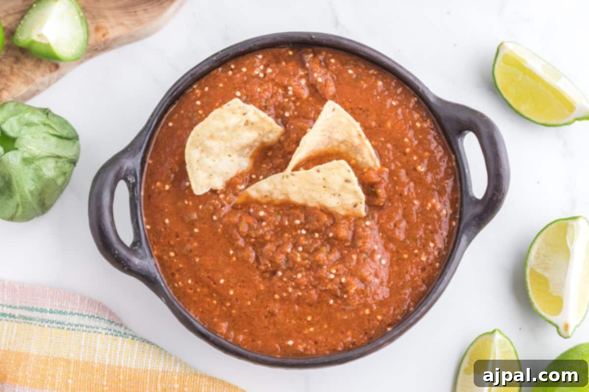 Smoky Chipotle Blaze 11 A ceramic bowl brimming with homemade Chipotle salsa is beautifully contrasted with a pile of golden tortilla chips, inviting a delicious dip.