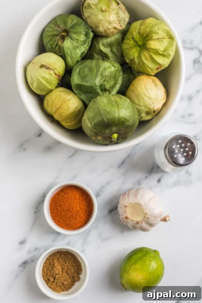 Smoky Chipotle Blaze 5 A collection of fresh ingredients laid out, featuring vibrant tomatillos, aromatic garlic, and various spices, all prepped for making Copycat Chipotle Hot Salsa.